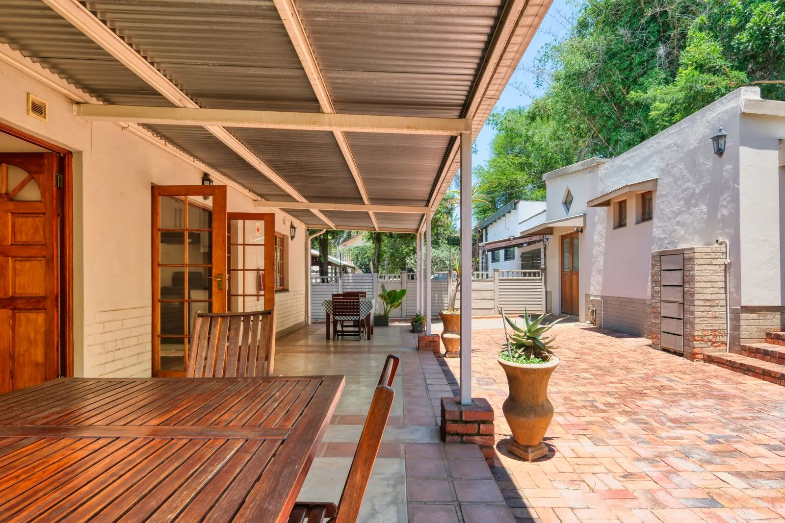 Inviting terrace with wooden furniture and potted plants in a Pretoria home.
